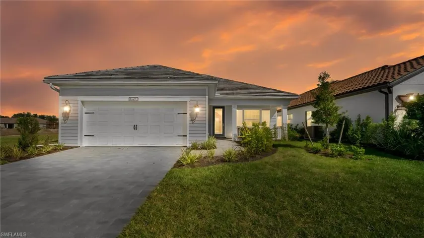 Bathed in the warm glow of a Florida sunset, this stunning Island-inspired residence showcases timeless architecture, elegant coach lighting, and exceptional curb appeal. From the upgraded elevation to the welcoming front porch, every detail reflects the quality and craftsmanship that make this home stand out within Verandah's premier golf and lifestyle community.