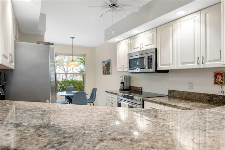 with new counter tops and updated appliances over looking the breakfast / siting area / recessed can lighting