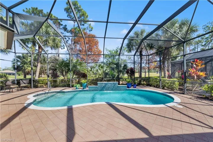 Swimming pool featuring a sunroom, a patio area, and glass enclosure