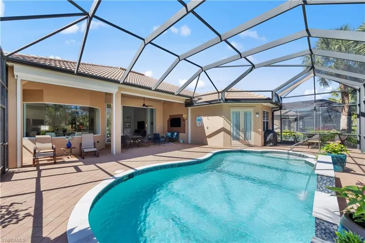 Swimming pool featuring a sunroom, glass enclosure, a patio area, and outdoor dining space