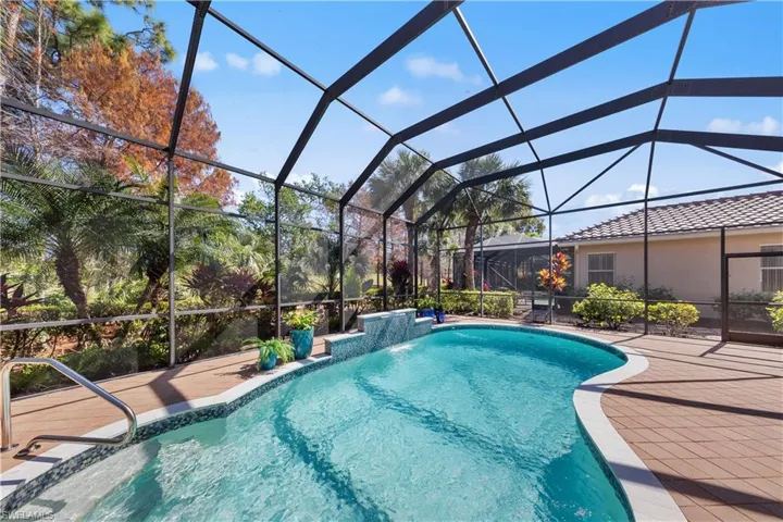 Swimming pool with glass enclosure, a sunroom, and a patio
