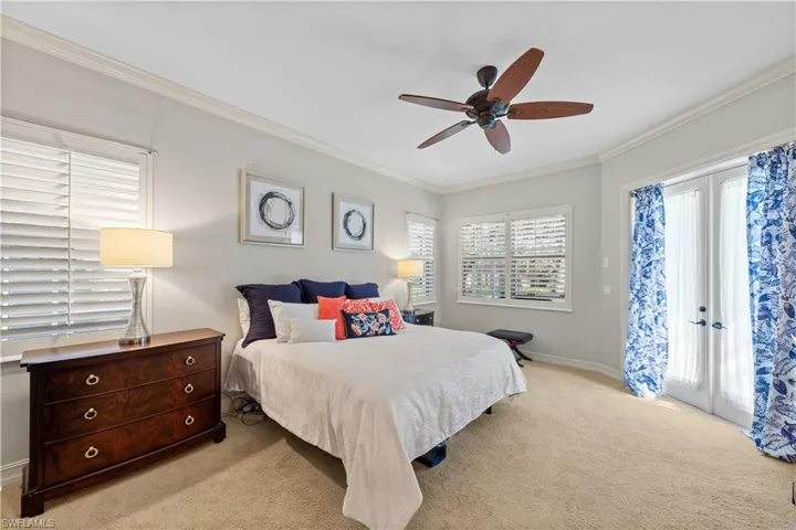 Bedroom featuring french doors, access to exterior, carpet floors, ornamental molding, and ceiling fan