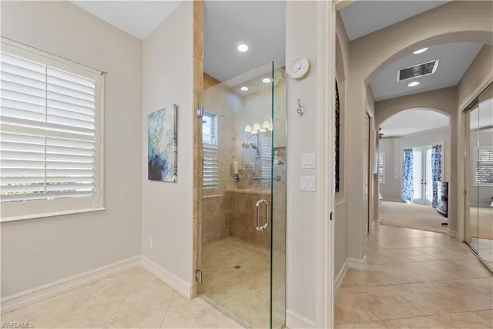 Bathroom with a shower stall, light tile patterned floors, and recessed lighting