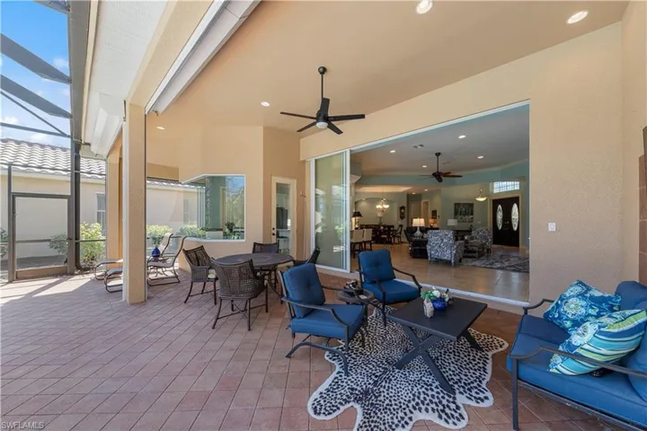 View of patio / terrace with an outdoor living / dining area, a sunroom, glass enclosure, and ceiling fan