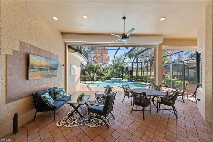 View of patio with glass enclosure, an outdoor pool, a sunroom, ceiling fan, and an outdoor hangout area