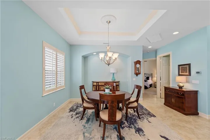 Dining area with a chandelier and a tray ceiling