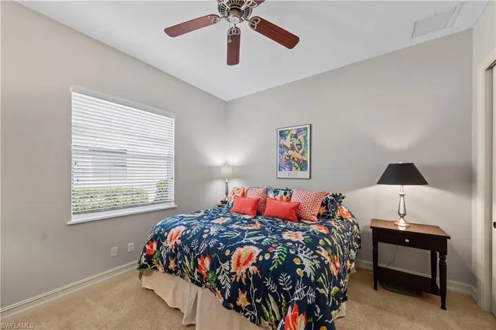 Bedroom with light colored carpet and ceiling fan