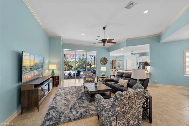 Living area with recessed lighting, a ceiling fan, crown molding, and light tile patterned flooring