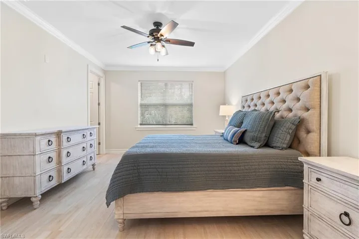 Bedroom with crown molding, light hardwood / wood-style floors, and ceiling fan