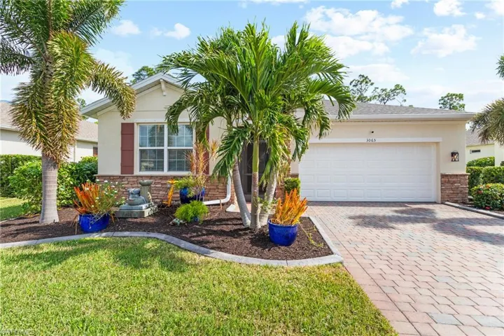 View of front of house featuring a front lawn and a garage