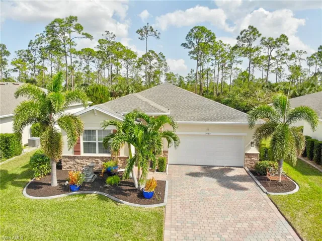 View of front of property with a garage and a front lawn