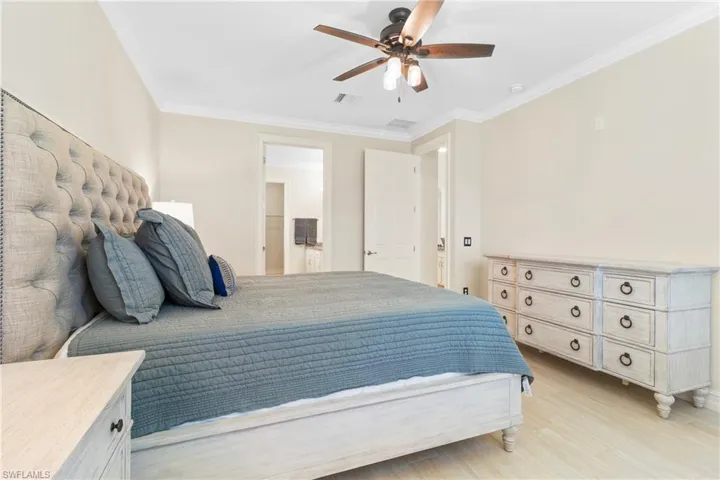 Bedroom featuring ornamental molding, light hardwood / wood-style floors, and ceiling fan