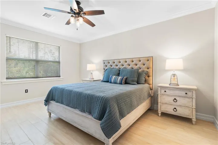 Bedroom featuring crown molding, light wood-type flooring, and ceiling fan