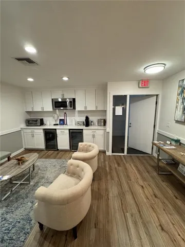 Waiting Room with wood-type flooring and wine cooler