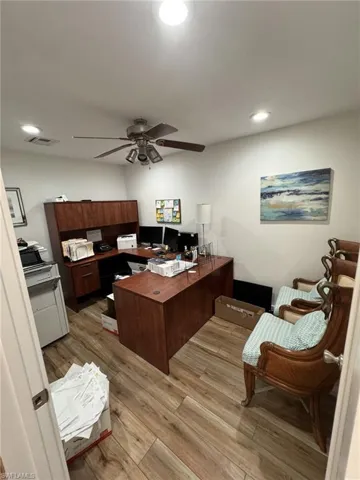 Office area with ceiling fan and light hardwood / wood-style flooring