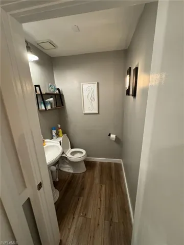 Bathroom featuring sink, wood-type flooring, and toilet