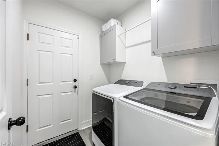 Laundry room featuring cabinet space, washing machine and clothes dryer, and wood finished floors
