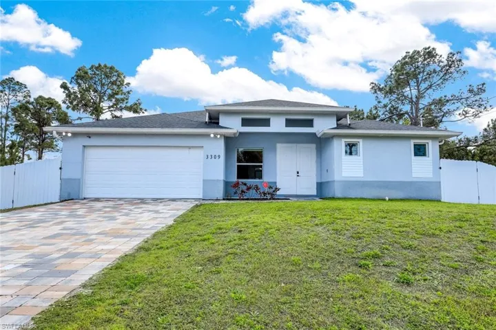 View of front of house featuring a gate, stucco siding, a garage, and driveway