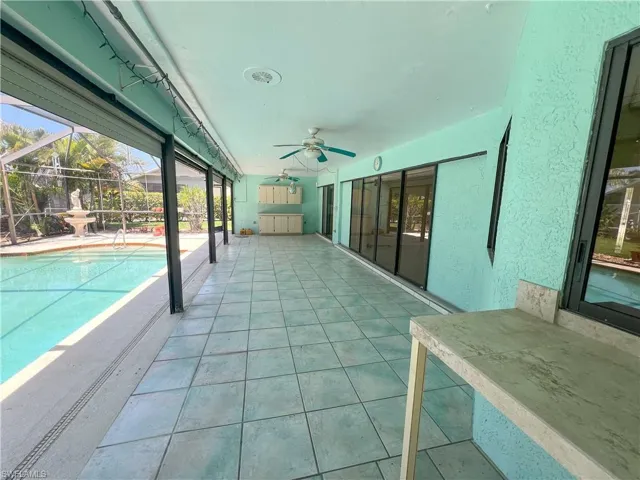 Outdoor pool featuring ceiling fan, a patio, and a lanai