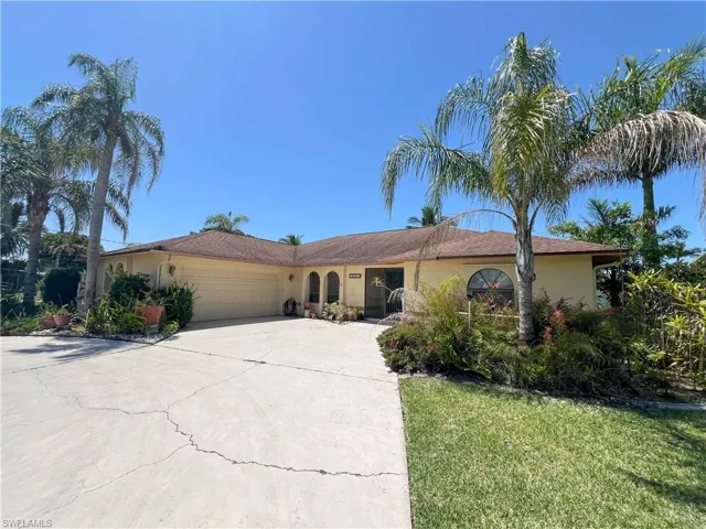 Single story home featuring stucco siding, an attached garage, concrete driveway, and a front yard