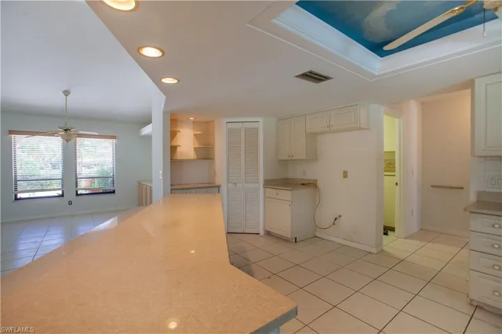 Kitchen with light tile patterned floors, light countertops, a ceiling fan, baseboards, and recessed lighting