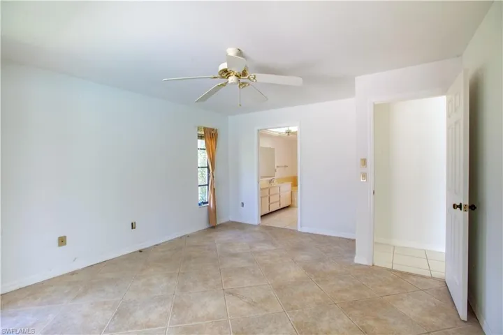 Empty room featuring ceiling fan and light tile patterned floors
