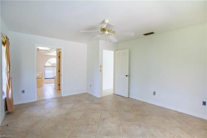 Spare room with light tile patterned floors, ceiling fan, and baseboards