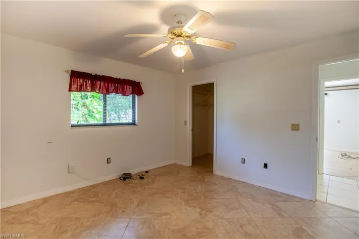 Unfurnished room with a ceiling fan and baseboards