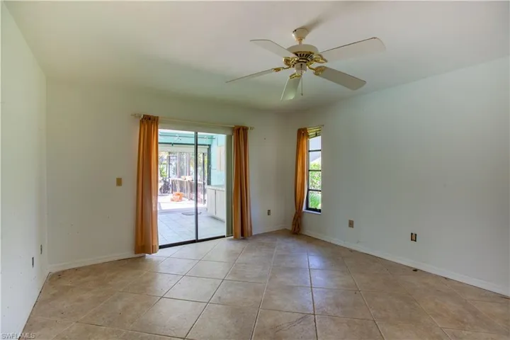 Spare room with light tile patterned floors, ceiling fan, and baseboards