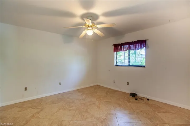 Spare room with a ceiling fan and baseboards