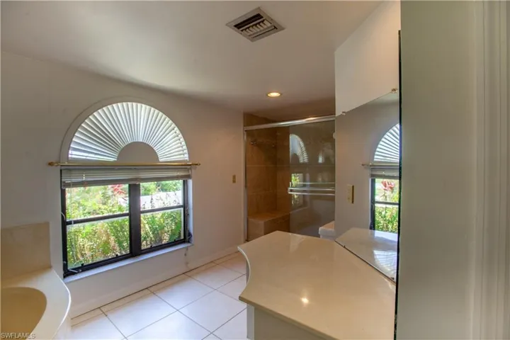 Bathroom with tile patterned floors, healthy amount of natural light, tiled shower, a bath, and recessed lighting