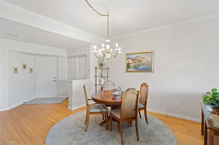 Dining area with an inviting chandelier, New Water proof laminate flooring, and crown molding