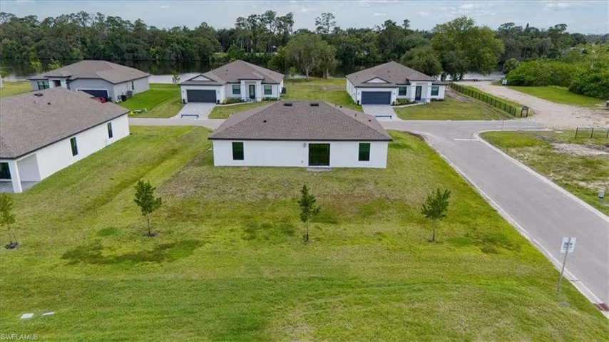 New construction residential neighborhood featuring modern single-story homes with white stucco exteriors and dark roofing