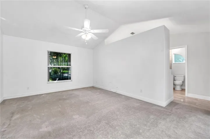 Master  bedroom with lofted ceiling, light colored carpet, and ceiling fan