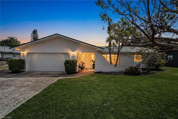 Front exterior with attractive curb appeal and evening lighting