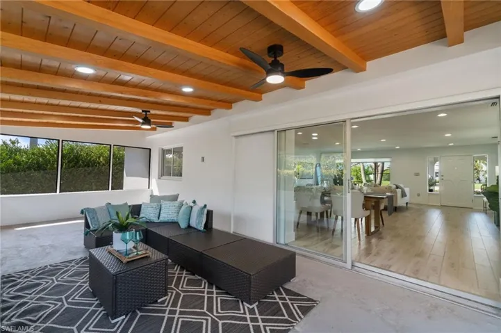 Open sunroom designed with ample seating and backyard views