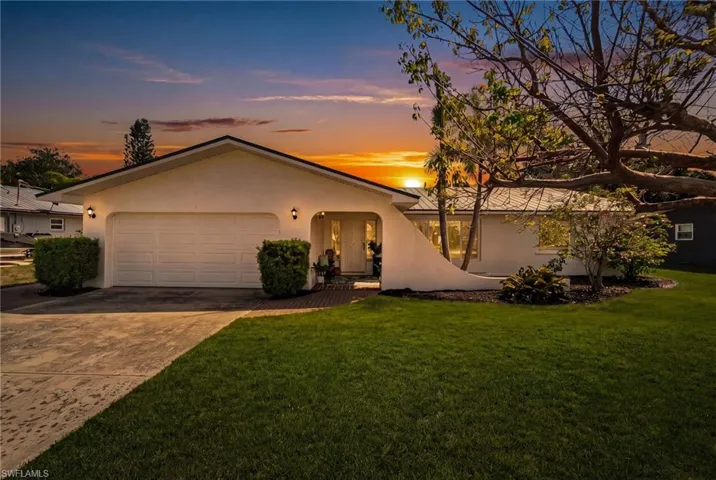 Charming front elevation with inviting curb appeal and mature landscaping
