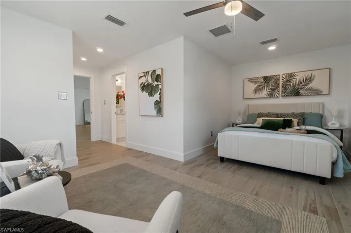 Spacious primary bedroom with ample natural light and neutral finishes