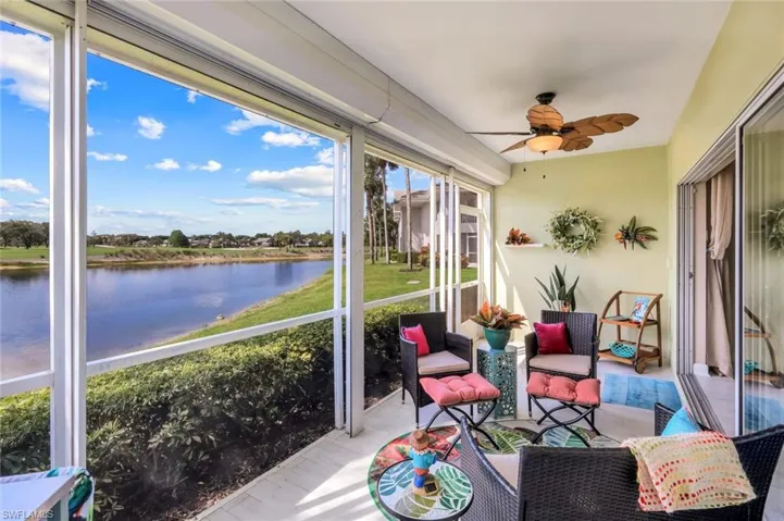 Sunroom with ceiling fan and a water view
