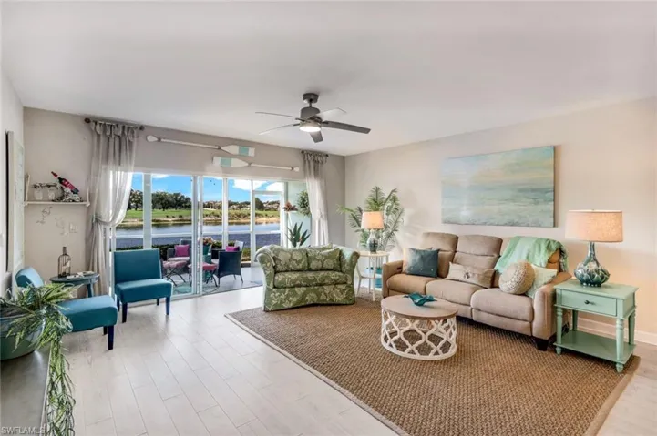 Living area featuring a ceiling fan, light wood-style floors, and a water view