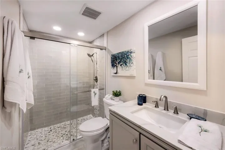 Full bathroom with vanity, a stall shower, and recessed lighting