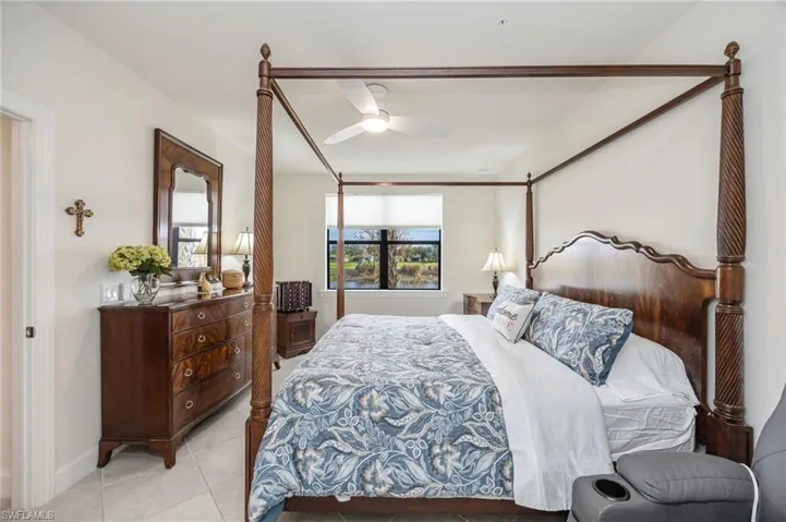 PRIMARY BEDROOM with a ceiling fan and light tile patterned floors