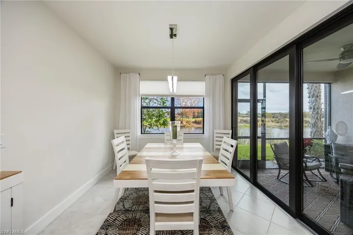 Dining room with light tile patterned flooring and a water view