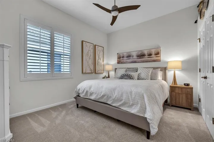 Bedroom with ceiling fan and light colored carpet