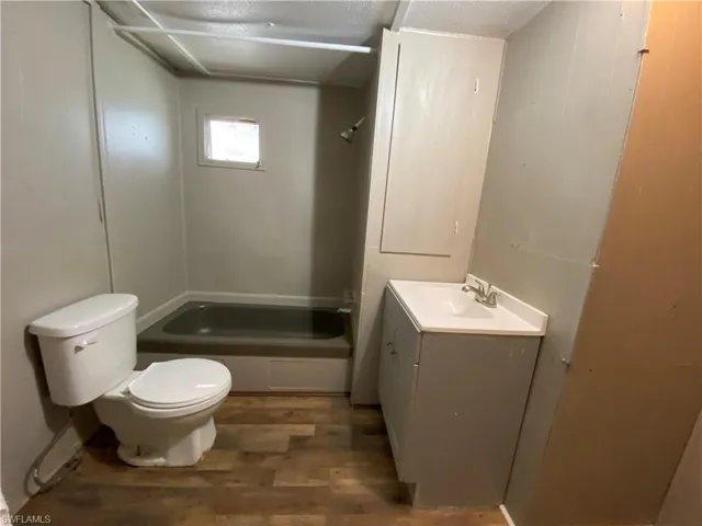Full bathroom featuring vanity, dark wood-style floors, and bathtub / shower combination