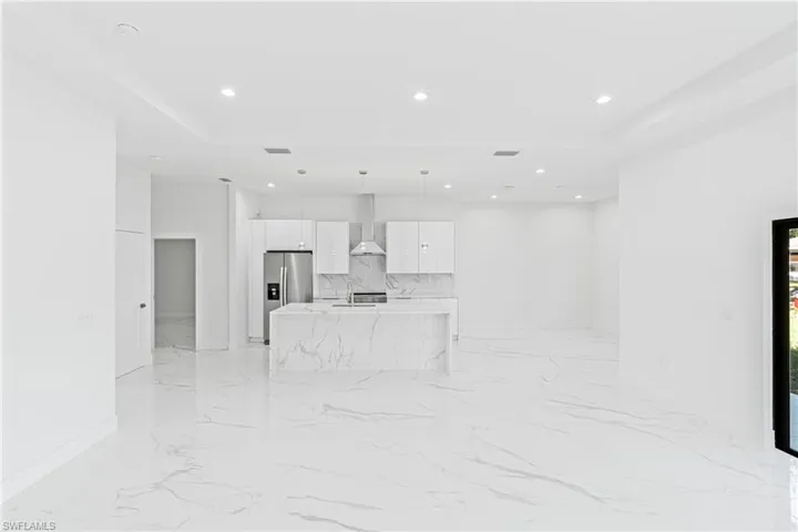 Unfurnished living room with recessed lighting and light marble finish flooring
