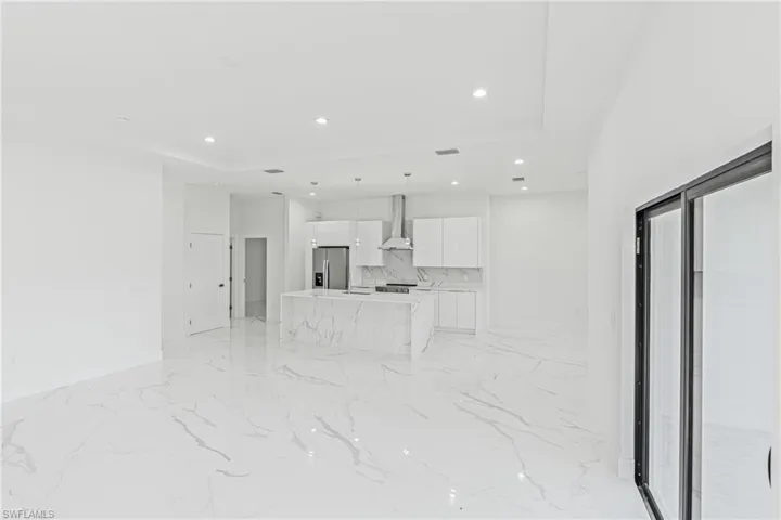 Unfurnished living room with recessed lighting and light marble finish floors