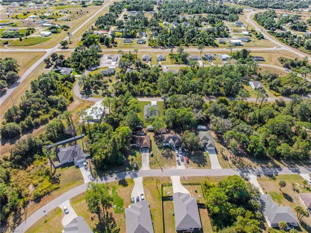 Aerial view of property and surrounding area featuring nearby suburban area