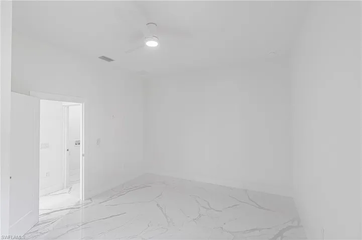 Spare room featuring light marble finish flooring and ceiling fan