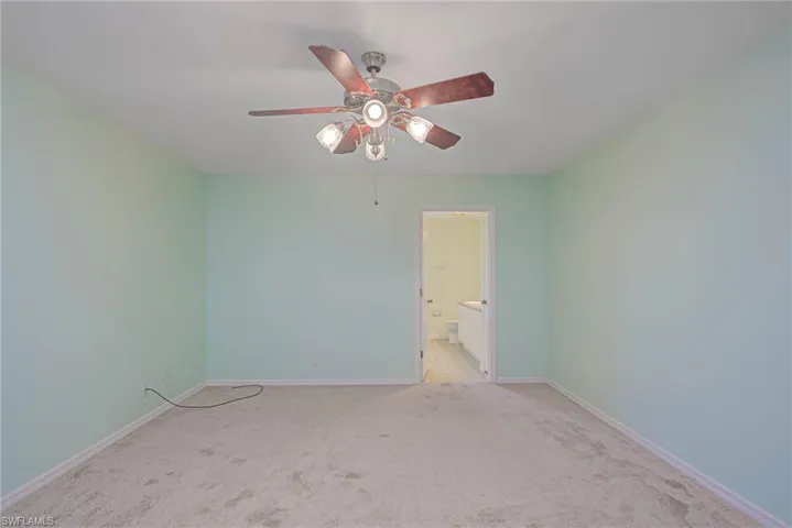Carpeted empty room with ceiling fan